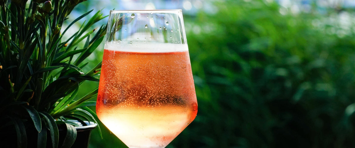 Cinsault: Perlendes Roséglas vor Grün