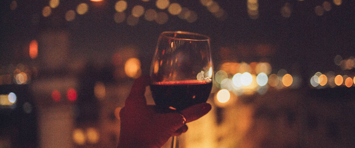 Portwein: Rotwein im Glas vor Lichtern der Stadt