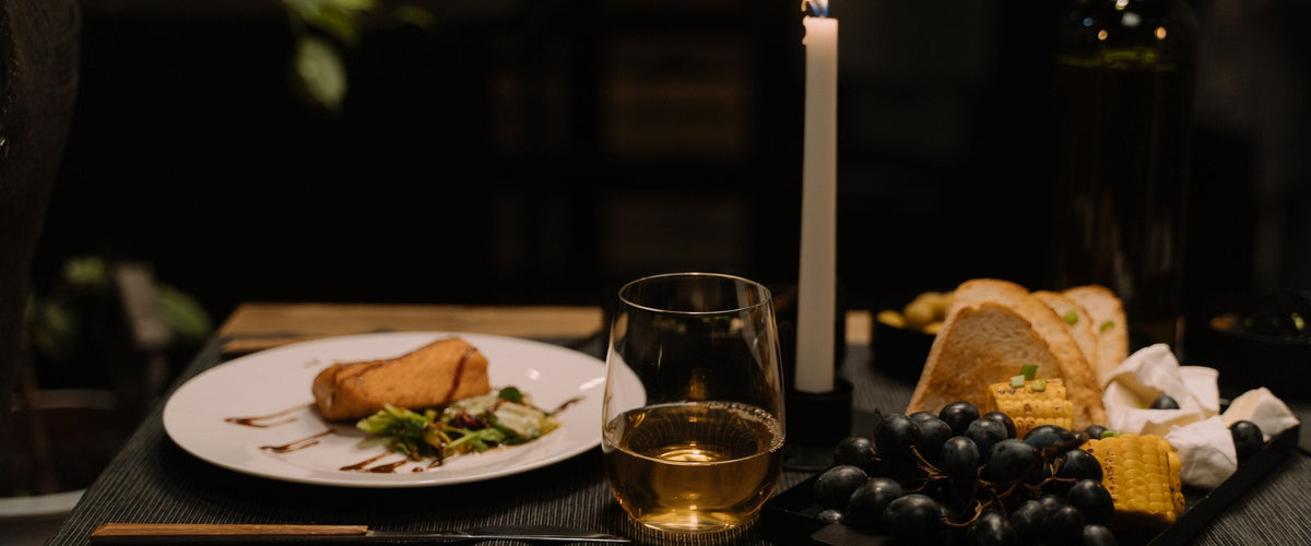 Wein zu Fisch: Fischteller bei Kerzenlicht, Weißweinglas