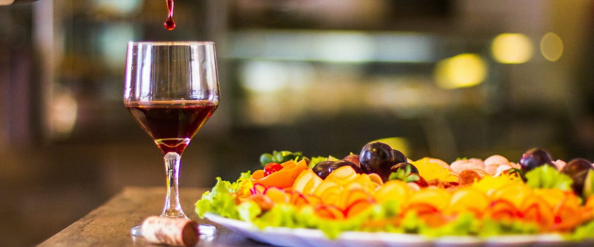Wein zu Gemüse & vegetarischen Gerichten: Rotwein wird eingeschenkt, buntes Gemüse