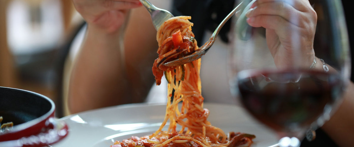 Wein zu Pasta & Risotto: Spaghetti auf Gabel, Rotwein im Vordergrund