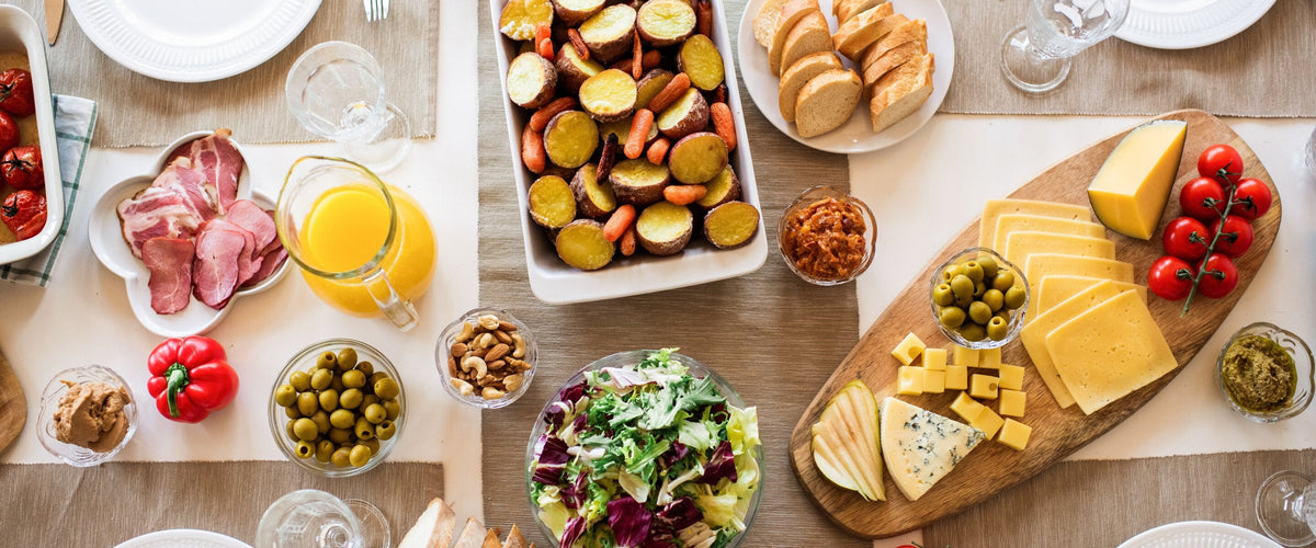 Wein zu Vorspeisen & Tapas: Antipasti-Tisch mit Käse, Oliven, Salat, Gläsern
