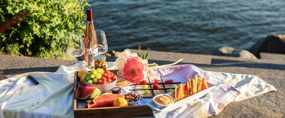 Weine bis 10 Euro: Picknickbrett am Wasser mit Rosé und Gläsern