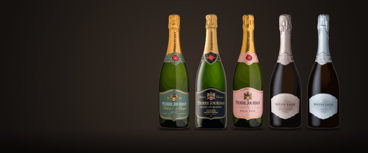 Fünf Flaschen Méthode Cap Classique aus Südafrika auf dunklem Grund: drei von Pierre Jourdan, zwei von Kleine Zalze