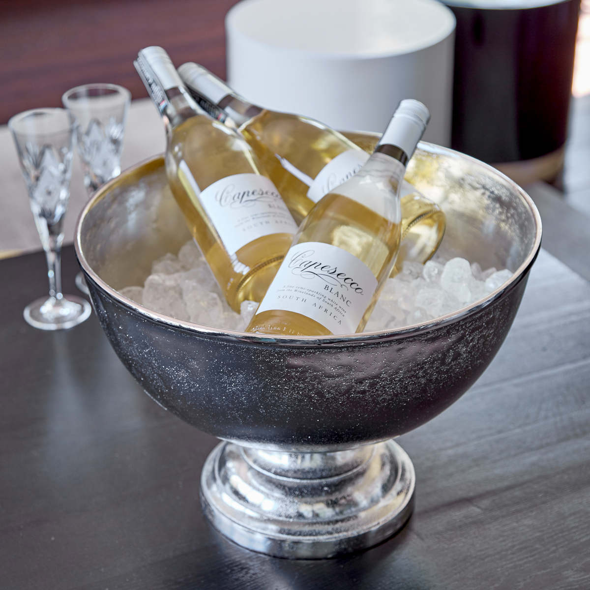 Flaschen Capesecco Perlwein in einem silbernen Eiskübel, daneben zwei Gläser