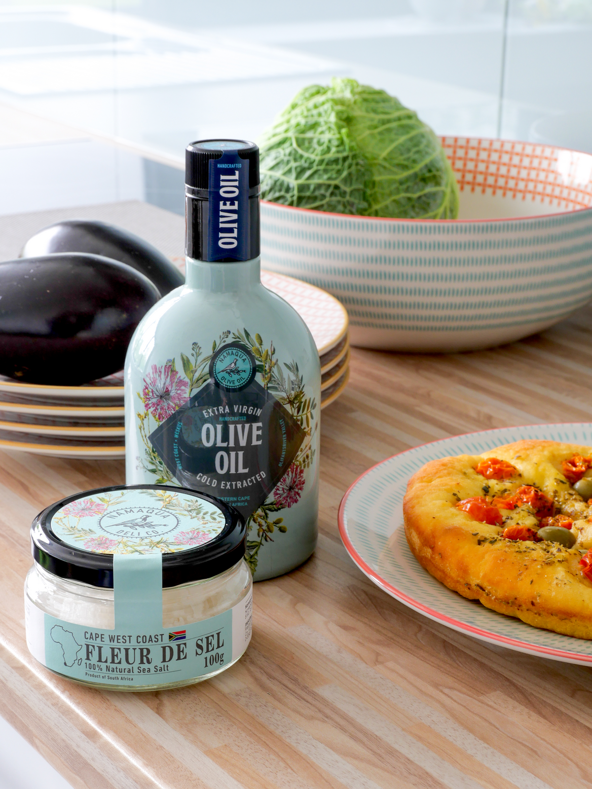 Glas Cape West Coast Fleur de Sel neben Olivenöl und Focaccia in einer Küche