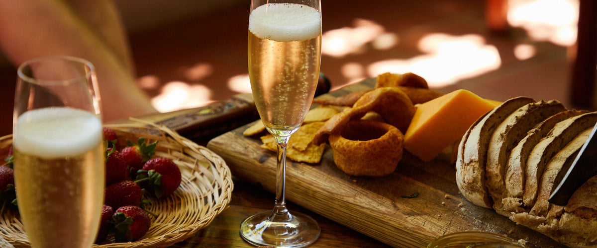 Frizzante & Perlwein: Sektgläser auf Brettern mit Brot und Käse