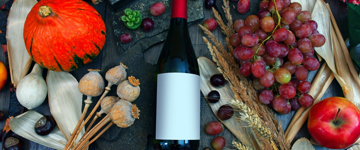 Herbstweine: Herbst-Stillleben von oben: Kürbis, Trauben, Mohnkapseln, Apfel
