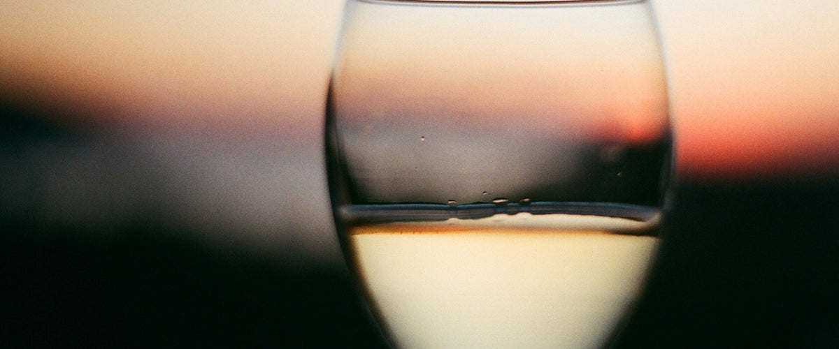 Sauvignon Blanc: Glas Weißwein vor Abendhimmel