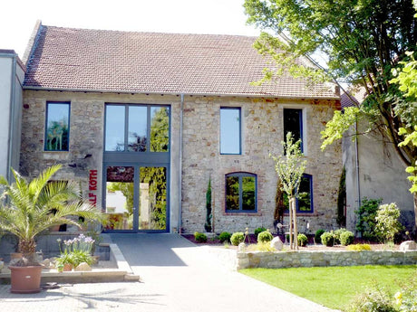 Das Gutsgebäude von Wein & Secco Köth mit Vorplatz und Bepflanzung