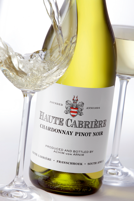 Haute Cabrière Chardonnay Pinot Noir wird in ein Weinglas eingeschenkt, Nahaufnahme des Etiketts