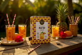 Punch Club Mai Tai 1,5-L-Box mit Gläsern, Ananas und Strohhalmen auf einem Tisch im Garten