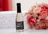 Piccolo-Flasche Perlwein Glückwunsch von Vom Feinsten neben einem Blumenstrauß und einem Geschenk