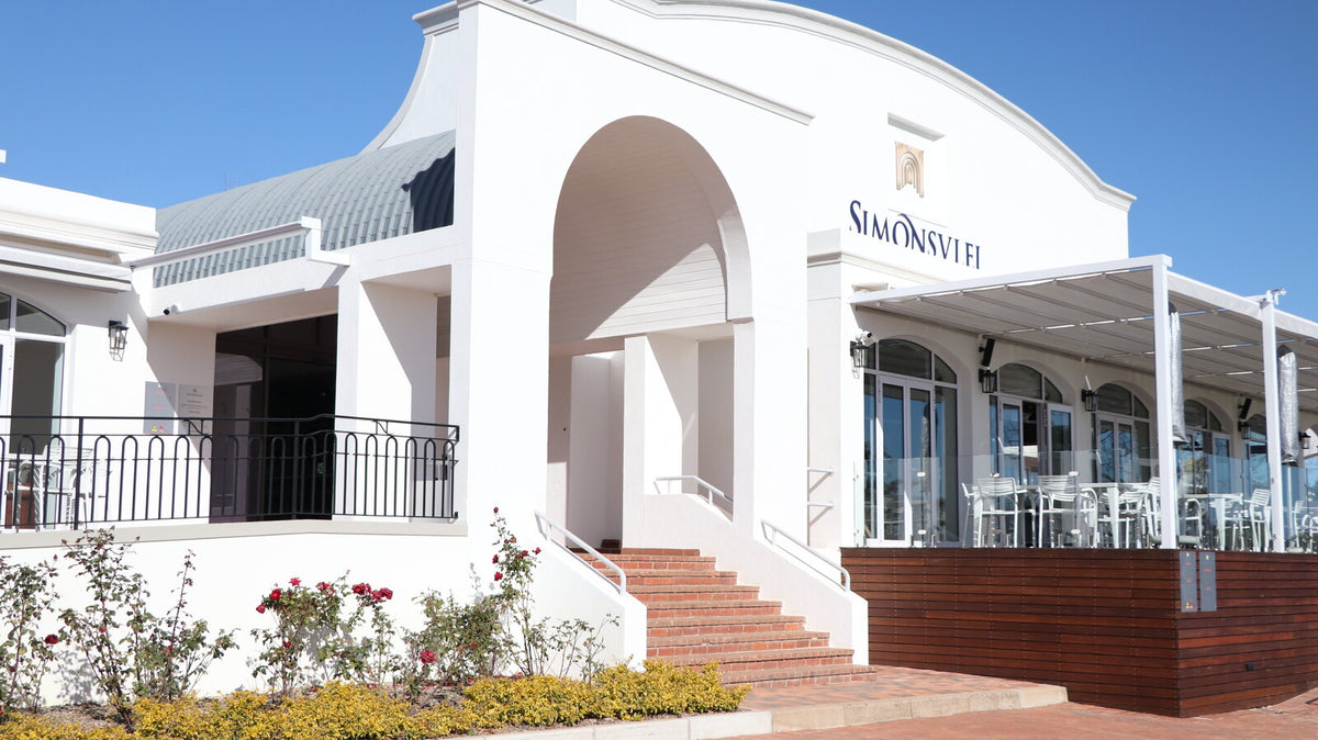 Das weiße Hauptgebäude des Weinguts Simonsvlei in Paarl